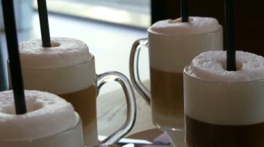 Güzel gözlük kahve latte ve masada kafede büyük köpük ile