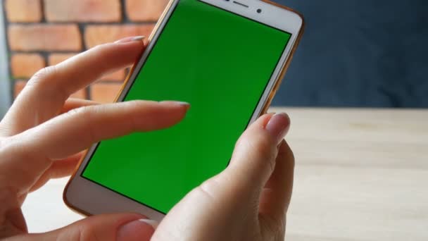 Smartphone de pantalla verde. Chroma Key en un teléfono inteligente blanco, las manos femeninas sostienen el teléfono móvil en la cafetería — Vídeos de Stock