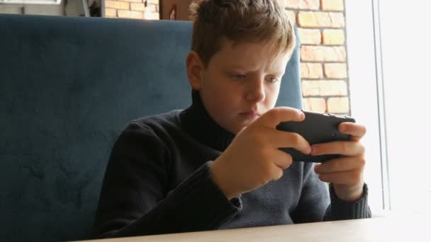 Garçon adolescent jouer un jeu sur noir smartphone — Video