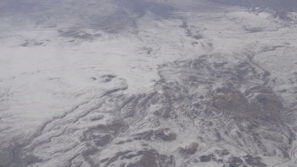 Beleza deslumbrante da cordilheira, ligeiramente coberta de neve, passando por nuvens, uma vista da janela do avião — Vídeo de Stock