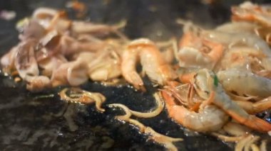 Yumurta ve bir tavada deniz ürünleri ile Tay erişte hazırlanması. Yağı bir tavada kızartma karides. Gece pazarı, Pattaya, Jomtien. Tayland Mutfağı. Piyasadaki Asya egzotik yemekler