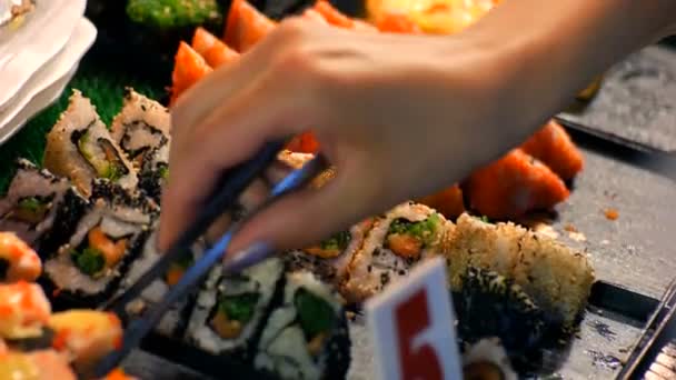 De vrouwelijke hand neemt de sushi rolletjes met voedsel pincet. Avondmarkt, Pattaya, Jomtien. Thaise keuken. Aziatische exotische gerechten op hij markt — Stockvideo