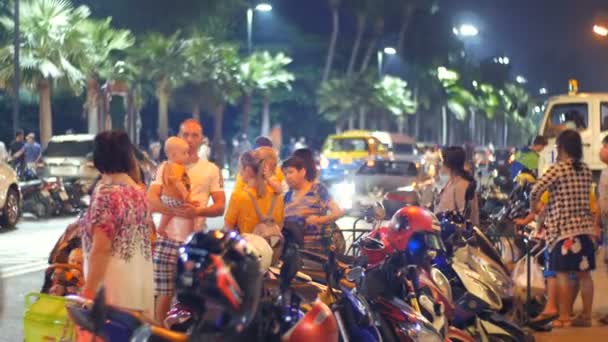 Pattaya, thailand - 23. Dezember 2017: Menschen stehen auf der Straße vor dem Nachtmarkt von Jomtien. die nächtliche Straße, auf der viele Menschen und Autos — Stockvideo