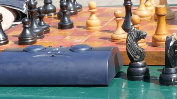 21 de abril de 2018 - Kamenskoye, Ucrania: Los niños juegan al ajedrez en la calle. Street Chess Tournament al aire libre, el reloj de ajedrez presiona la mano — Vídeos de Stock