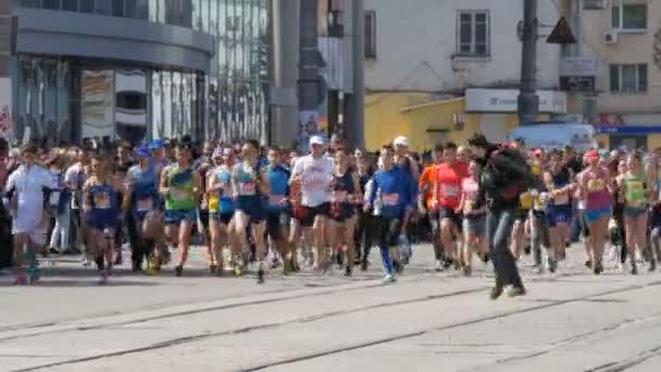 21 de abril de 2018 - Kamenskoye, Ucrania: Carrera de maratón, la gente corre desde el principio, el camarógrafo con cámara corre delante de la multitud — Vídeos de Stock