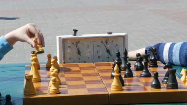 21 de abril de 2018 - Kamenskoye, Ucrania: Los niños juegan al ajedrez en la calle. Street Chess Tournament al aire libre, el reloj de ajedrez presiona la mano — Vídeo de stock