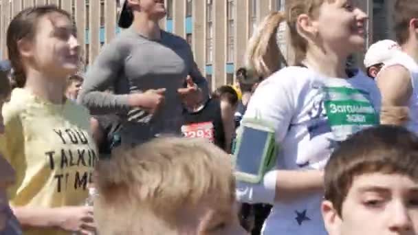 Le 21 avril 2018 - Kamenskoye, Ukraine : un grand nombre de jambes des peuples font un échauffement avant la course de marathon. Sauts et squats d'un grand nombre de personnes sur la place — Video