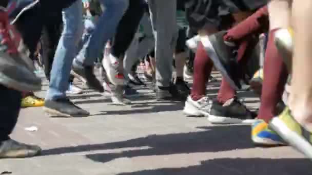 21. dubna 2018 - Kamenskoye, Ukrajina: velký počet lidí nohy mají rozcvičení před závodem maraton. Skoky a dřepy velkého počtu lidí na náměstí — Stock video