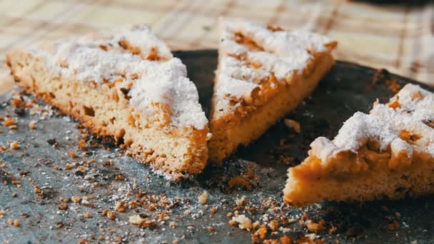 Apfelkuchen aus Mürbeteig in der heimischen Küche. Stücke halb verzehrten Kuchens auf einem Tisch. hausgemachtes Backen. — Stockvideo