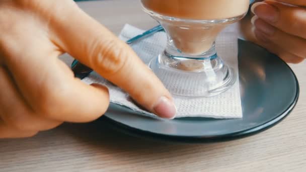 Donna sta girando un piattino e un bicchiere con un latte in un caffè, sul piattino si trova un biscotto sotto forma di chicchi di caffè — Video Stock
