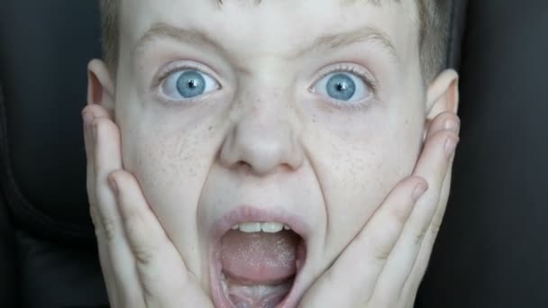 Drôle joyeux garçon aux yeux bleus avec des taches de rousseur garçon qui est surpris à la caméra — Video