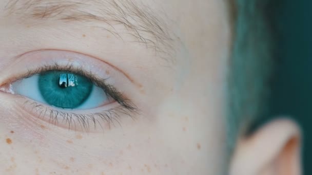 Türkisfarbene Augen eines blonden Teenagers mit roten Sommersprossen im Gesicht und langen weißen Wimpern Nahaufnahme — Stockvideo