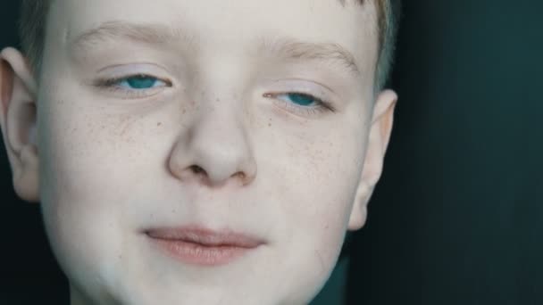 Aufrichtig gut gelauntes Babygesicht eines blauäugigen blonden Jungen mit Sommersprossen, der in die Kamera lächelt — Stockvideo