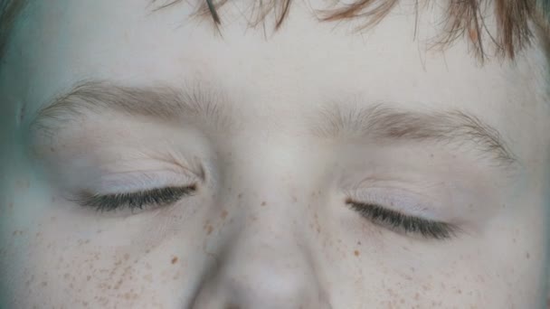 Turkusowe oczy nastolatek blond chłopiec z czerwone piegi na twarzy i długie białe rzęsy zbliżenie — Wideo stockowe