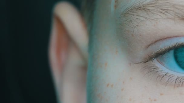 Turquesa ojos de niño rubio adolescente con pecas rojas en la cara y largas pestañas blancas de cerca ver — Vídeos de Stock