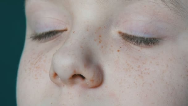 Yeux turquoise d'un adolescent blond avec des taches de rousseur sur le visage et de longs cils blancs qui regarde la caméra de près — Video