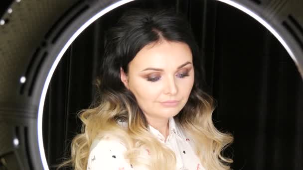 Beautiful young woman with long hair extensions dyed black and white ombre and beautiful bright evening professional makeup smoky eyes posing in front of camera — Stock Video