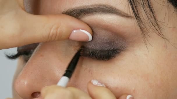 Un cepillo gris especial o un lápiz para maquillaje de ojos aplica sombra de ojos en el párpado inferior — Vídeos de Stock