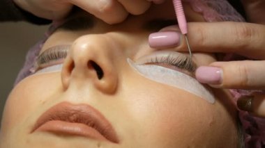 Kirpikleri kıvırmak için silikon bigudiler ya da bigudiler. Kaplama ve botoks için profesyonel prosedür modern şifa kirpiklerini kirletir. Özel taraklı bir güzellik uzmanı kirpiklerini düzgünce düzleştiriyor.