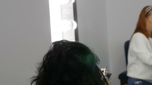 20 de septiembre de 2019 - Kamenskoye, Ucrania: El peinado profesional hace rizos de rizos con la ayuda de una rizadora a una hermosa joven con ombre de pelo largo en el estudio de belleza — Vídeo de stock