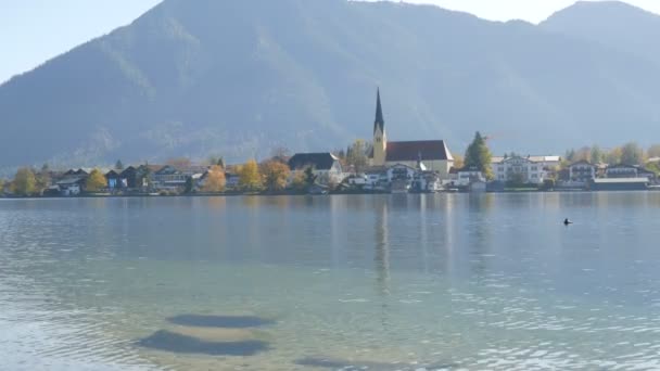 Belle vieille église dans un endroit animé sur le fond des Alpes bavaroises sur la rive du lac Tegernsee — Video