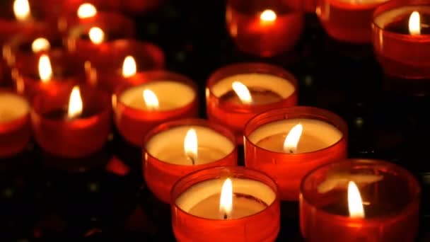 Burning red round candles in catholic church — Stockvideo