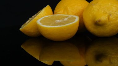 Siyah arka planda taze, sulu, sarı bir limon