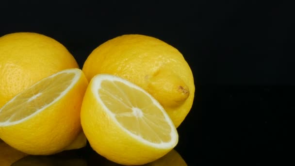 黒の背景に新鮮なジューシーな黄色のレモンを熟す回転 — ストック動画