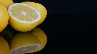 Siyah arka planda taze, sulu, sarı bir limon