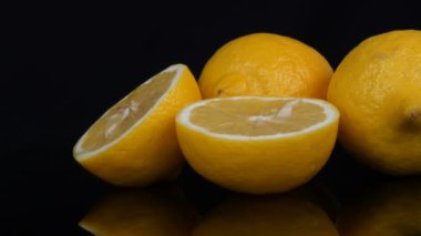 Olgun taze sulu sarı limon siyah arkaplanda dönüyor
