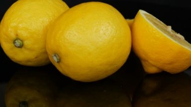 Olgun taze sulu sarı limon siyah arkaplanda dönüyor