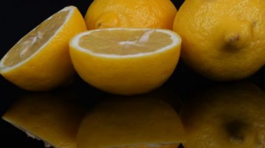 Olgun taze sulu sarı limon siyah arkaplanda dönüyor