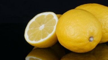 Olgun taze sulu sarı limon siyah arkaplanda dönüyor