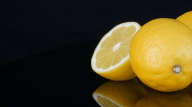 Siyah arka planda taze, sulu, sarı bir limon