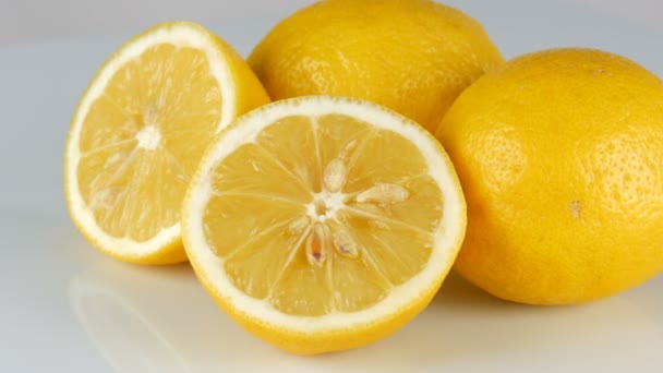 Reife frische saftige gelbe Zitrone auf weißem Hintergrund drehen — Stockvideo