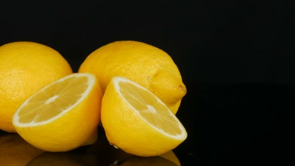 Reife frische saftige gelbe Zitrone auf schwarzem Hintergrund — Stockvideo