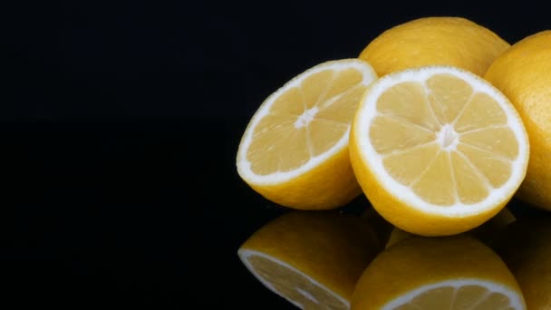 Rijp verse sappige gele citroen op zwarte achtergrond — Stockvideo
