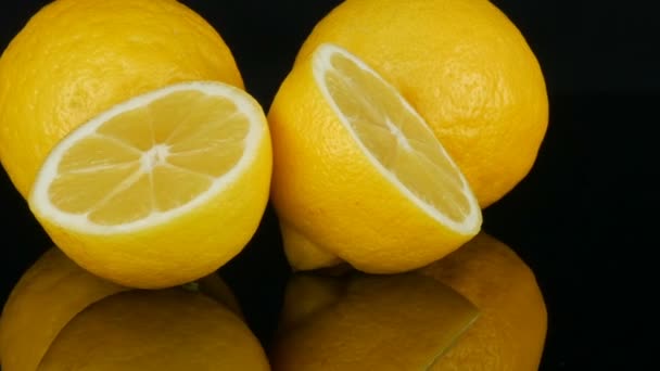 Ripe fresh juicy yellow lemon on black background rotate — Stock Video