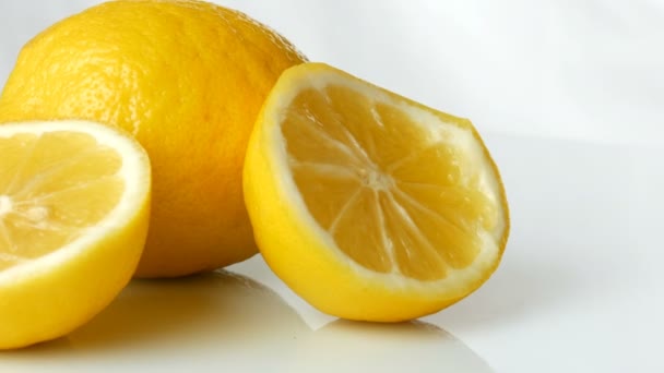 Спелые свежие сочные желтый лимон на белом фоне вращаются — стоковое видео