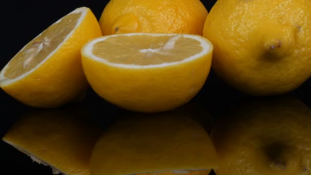 Ωρίμανση φρέσκο ζουμερό κίτρινο λεμόνι σε μαύρο φόντο περιστρέφεται — Αρχείο Βίντεο