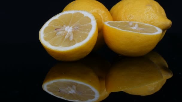 成熟新鲜多汁的黄色柠檬，黑色底色 — 图库视频影像
