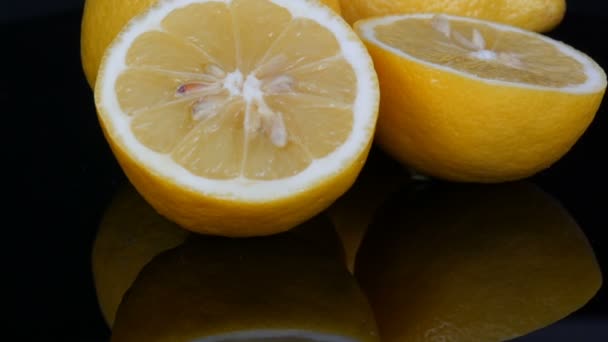 Спелые свежие сочные желтый лимон на черном фоне вращаются — стоковое видео