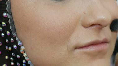 Profesyonel fırça ile blendable vurgu modeli yakın yukarı yüzüne uygulanır. Stüdyoda güzel kahverengi gözleri ile genç kız modeli. Profesyonel makyaj yüksek moda makyaj sanatçısı