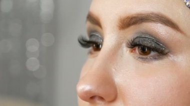 Profesyonel fırça ile blendable vurgu modeli yakın yukarı yüzüne uygulanır. Stüdyoda güzel kahverengi gözleri ile genç kız modeli. Profesyonel makyaj yüksek moda makyaj sanatçısı