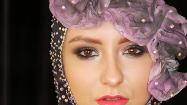 Retrato de una elegante modelo de alta moda con expresivos ojos ahumados maquillaje posando en el estudio sobre un fondo negro de terciopelo y reflector en los ojos — Vídeo de stock