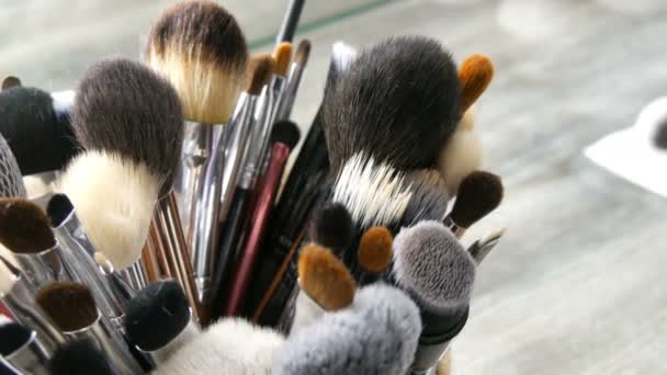 Set de cepillos profesionales para maquillaje sobre mesa en vestidor. Industria de la moda. Desfile de moda entre bastidores. Maquillaje artista toma un cepillo . — Vídeos de Stock