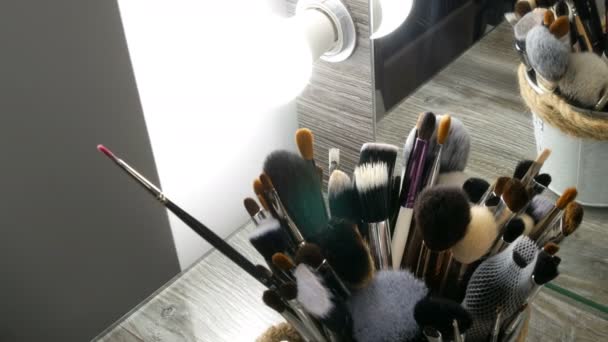 Set de cepillos profesionales para maquillaje sobre mesa en vestidor. Industria de la moda. Desfile de moda entre bastidores. Maquillaje artista toma un cepillo . — Vídeos de Stock