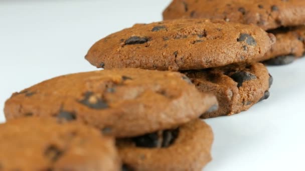 Galletas de chocolate sobre fondo blanco elegante ack y una superficie de espejo — Vídeos de Stock