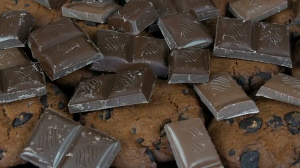Шоколадное печенье и кусочки шоколада на стильном черном фоне и зеркальной поверхности — стоковое видео