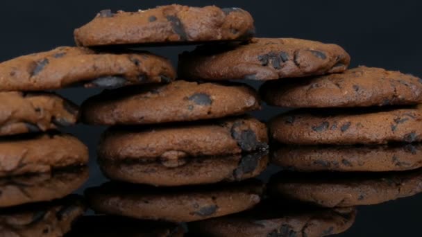 Biscoitos de chocolate no fundo preto elegante e uma superfície de espelho — Vídeo de Stock